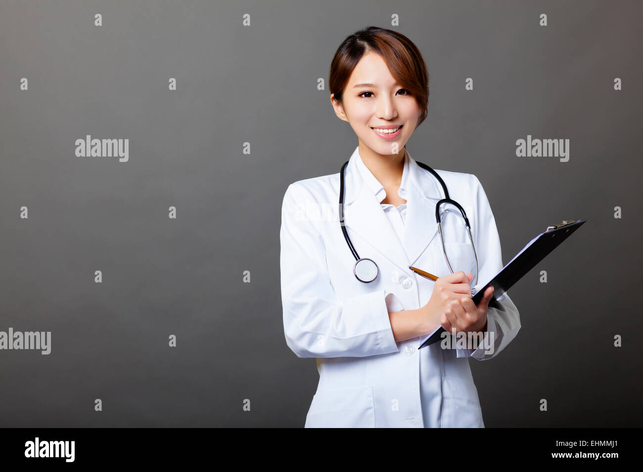 Smiling female doctor with clipboard Banque D'Images