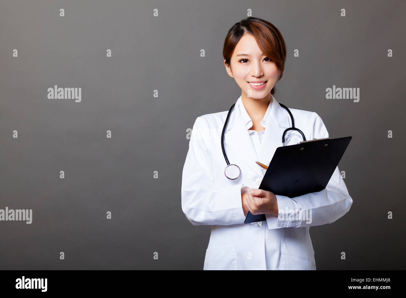 Smiling female doctor with clipboard Banque D'Images