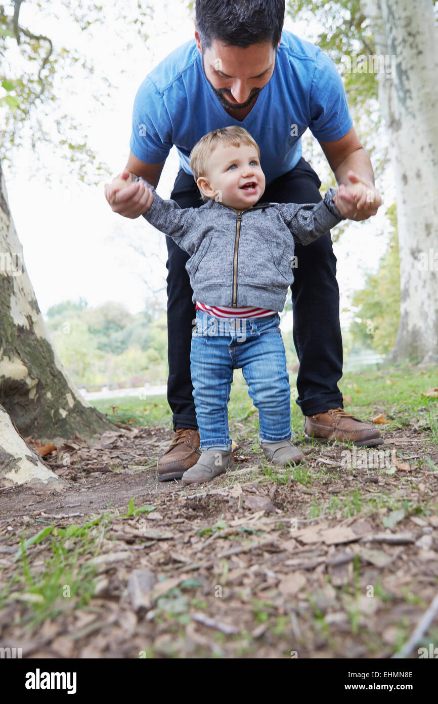 Caucasian father helping baby son dans la nature Banque D'Images