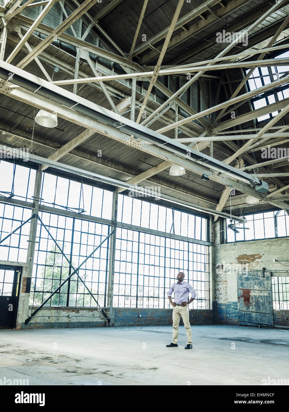 Black businessman standing in empty warehouse Banque D'Images