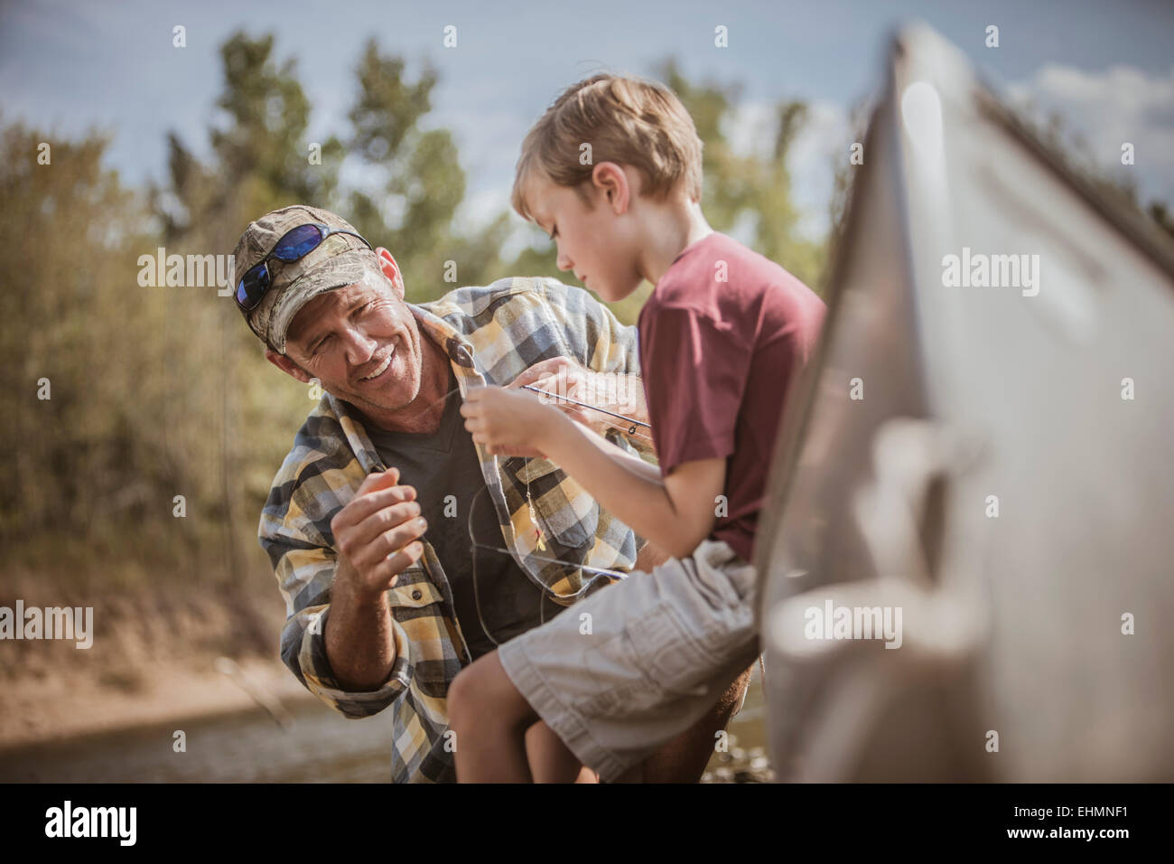 Portrait père fils d'enseignement pour attacher des attraits de pêche Banque D'Images