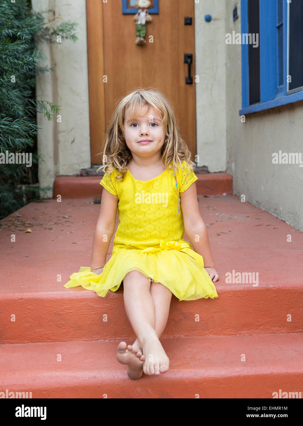 Caucasian girl sitting on/stoop Banque D'Images