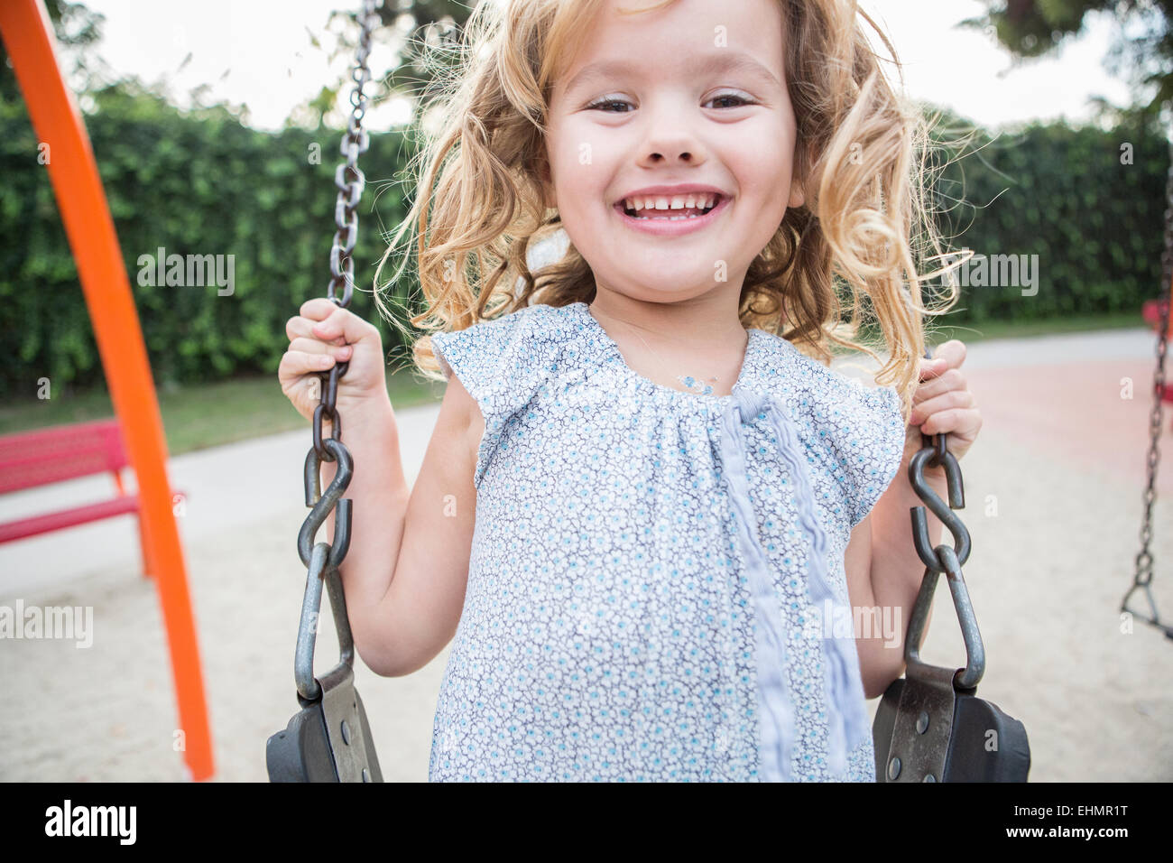 Caucasian girl playing on swing Banque D'Images