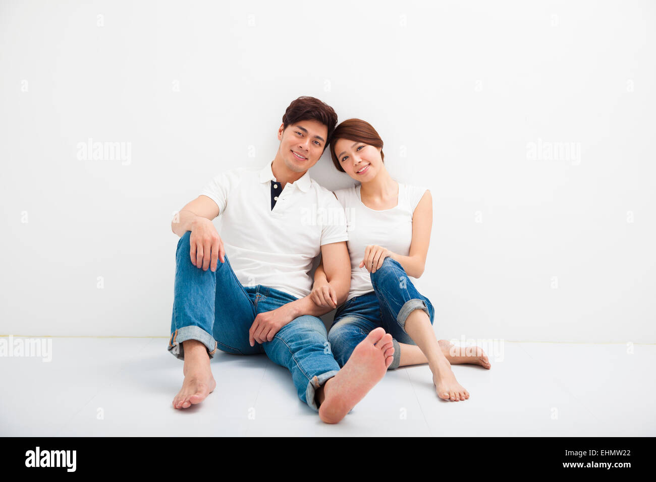 Happy Young Couple Sitting on Floor Banque D'Images