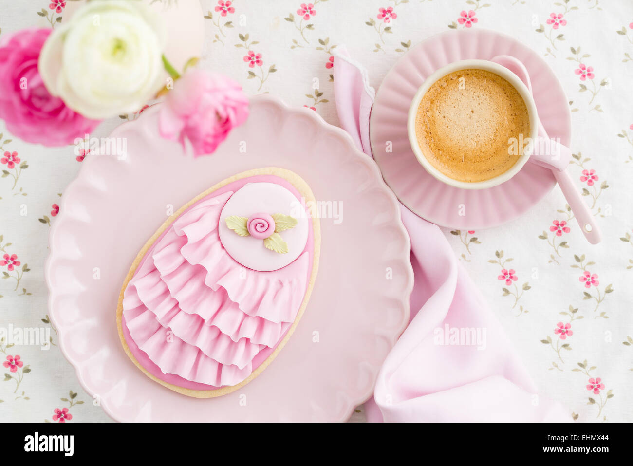 Gros oeufs de Pâques avec des biscuits au sucre rose fondantes et pink ruffles, fleur et une tasse de café Banque D'Images