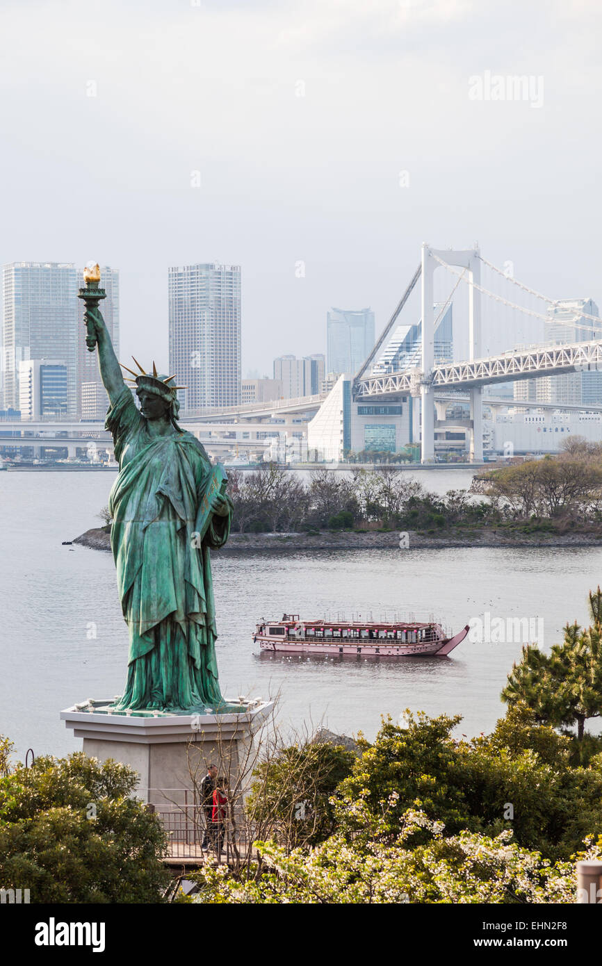 Statue de la liberté sur le bord de la baie de Tokyo et le Rainbow Bridge, au Japon. Banque D'Images