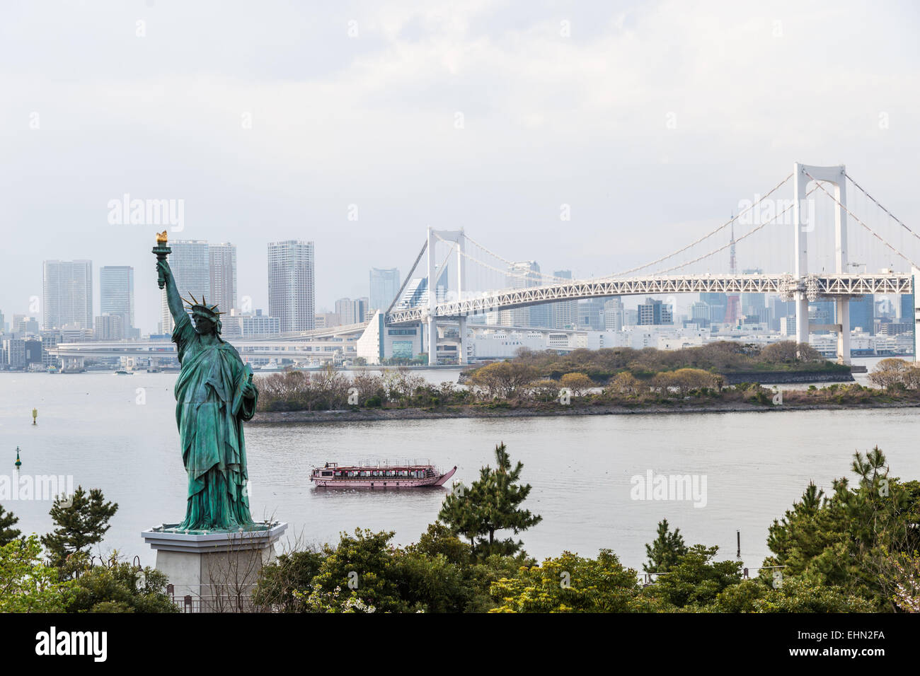 Statue de la liberté sur le bord de la baie de Tokyo et le Rainbow Bridge, au Japon. Banque D'Images