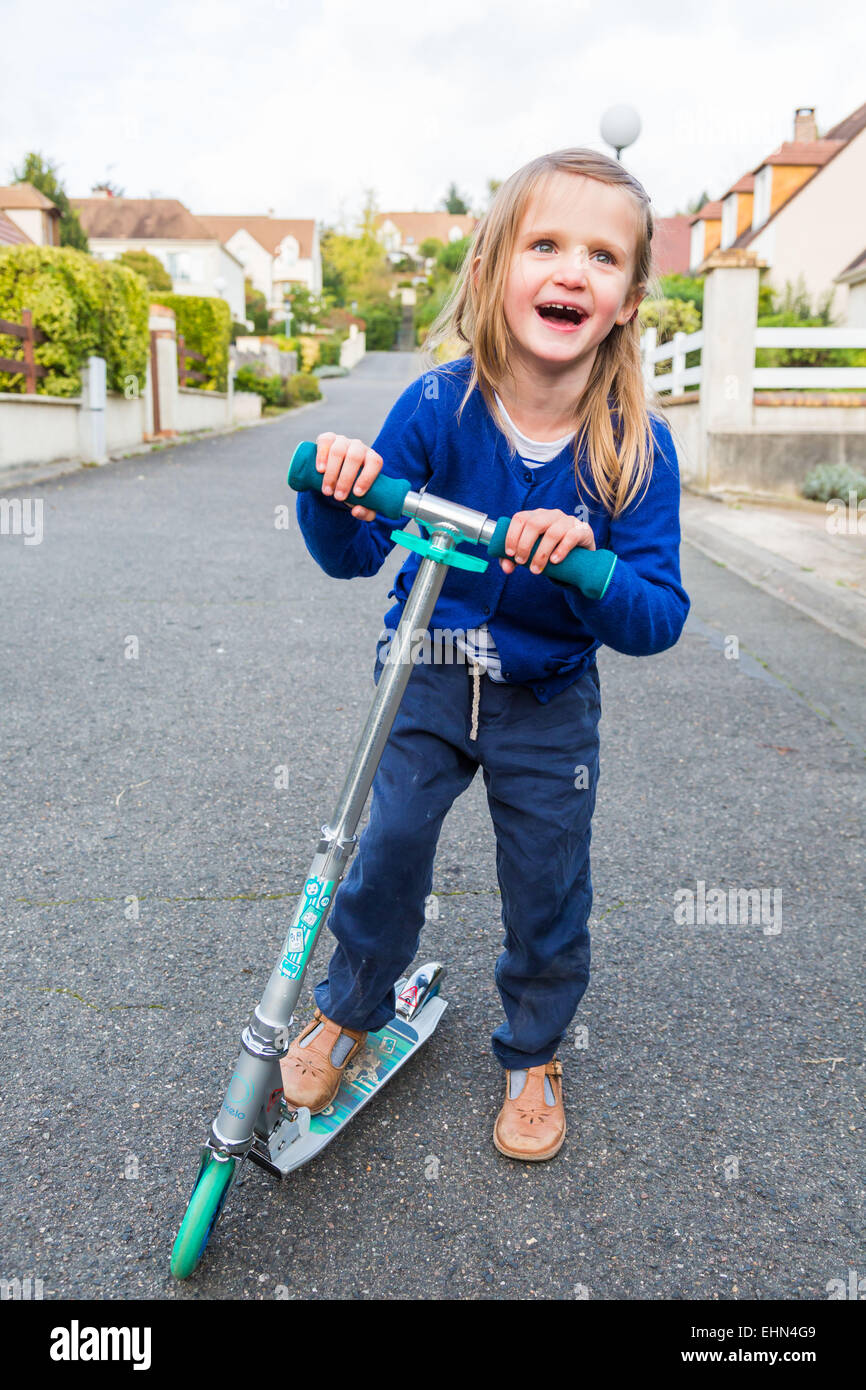 Les enfants sur les scooters à l'extérieur. Banque D'Images