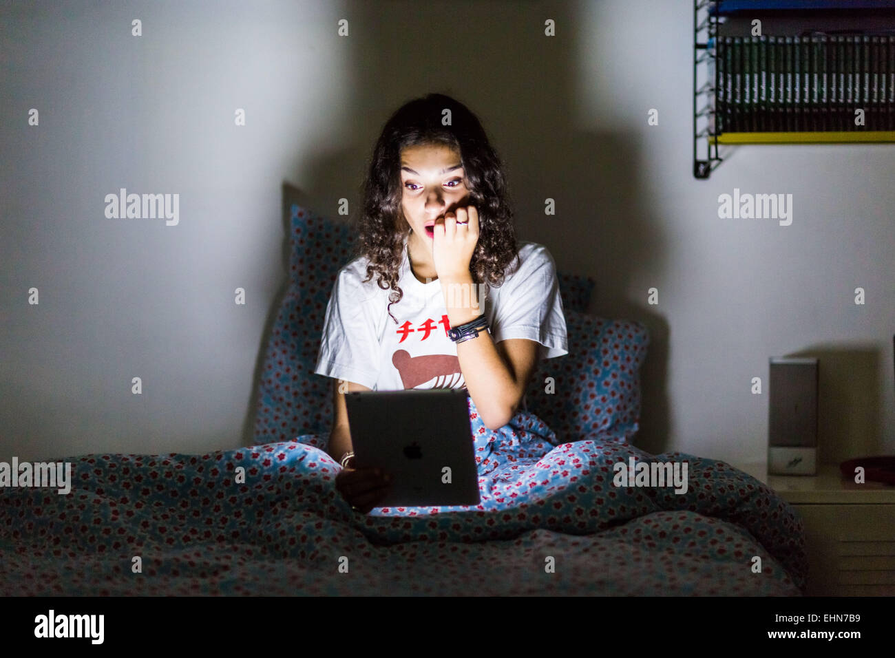 Teenage girl using a digital tablet la nuit. Banque D'Images
