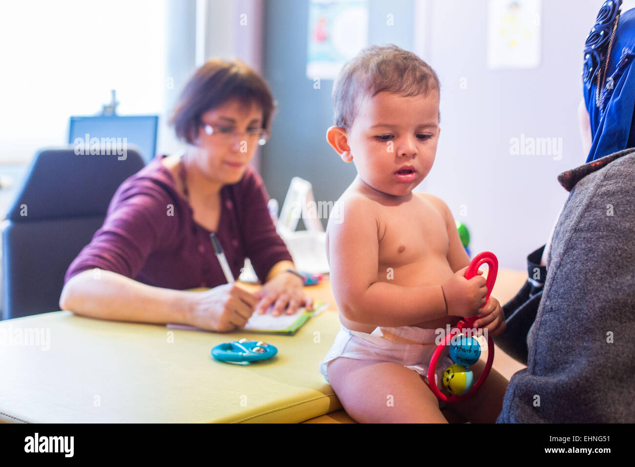 Médecin de remplir un carnet de santé de l'enfant, la protection maternelle et infantile, Charente, France. Banque D'Images