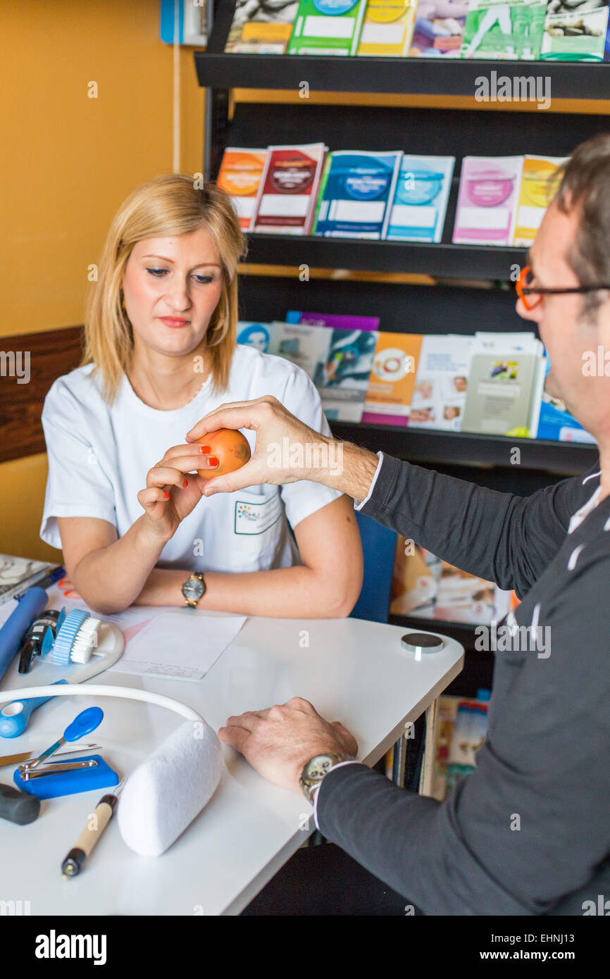 L'évaluation fonctionnelle et de conseils sur les aides techniques faites par un ergothérapeute avec un patient avec douleur commune, l'hôpital de Limoges, France. Banque D'Images