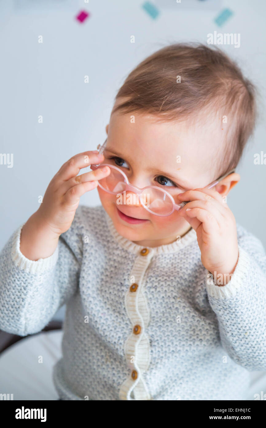 18 mois bébé garçon portant des lunettes. Banque D'Images