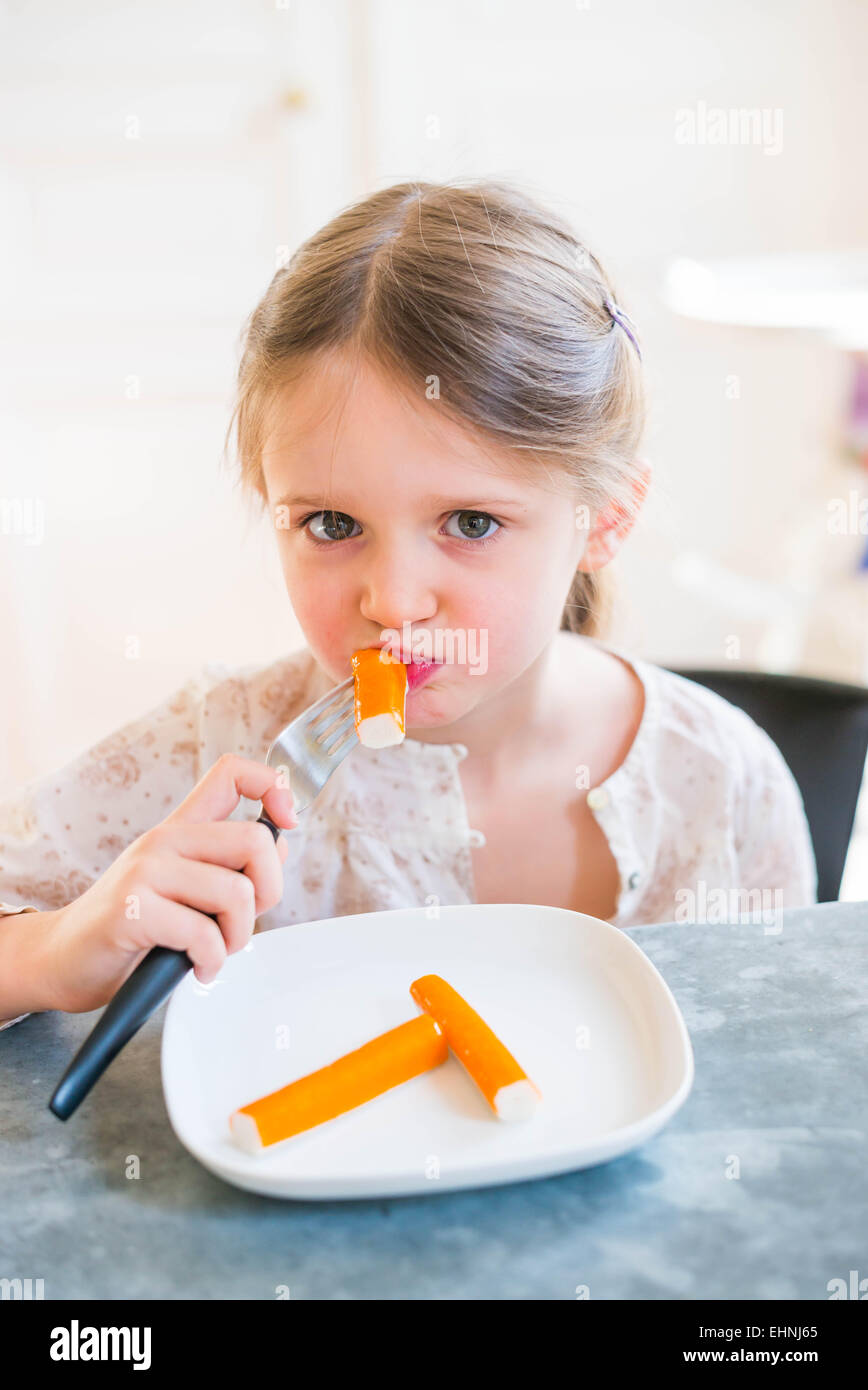 5 year-old girl eating surimi. Banque D'Images