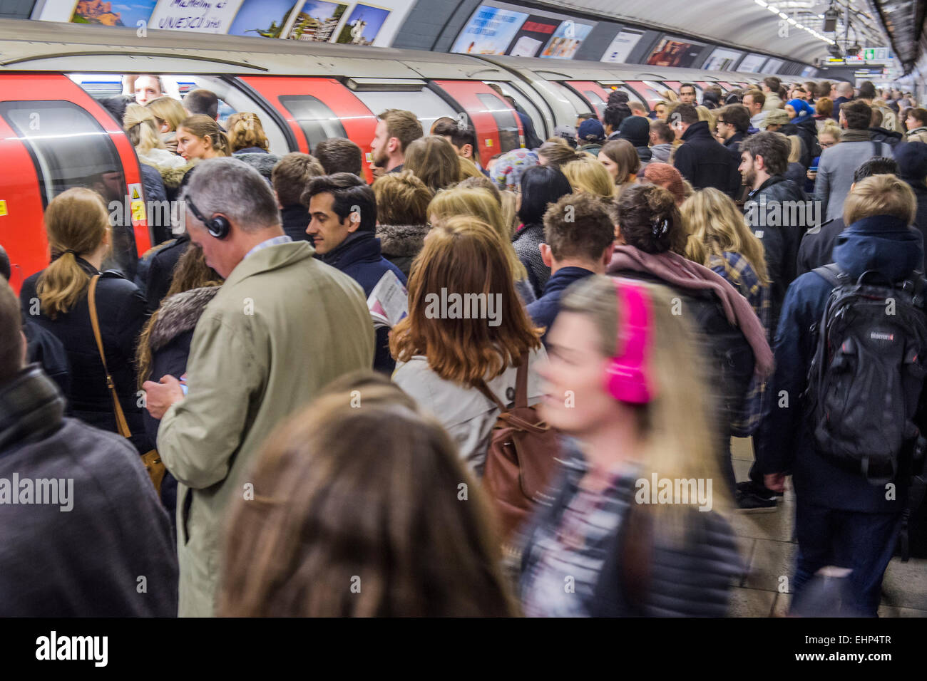 Londres, Royaume-Uni. 16 mars, 2015. Passagers attendant paniers Northern Line trains à Stockwell. Ils sont bombardés par des annonces que toutes les lignes ont un bon service et sont confrontés par un signe utile, mis en place par TFL, leur disant de ne pas foule autour d'une porte. Malheureusement, ils sont forcés par poids du nombre d'être dangereusement près du bord de la plate-forme. Stockwell Station sur la ligne du Nord, Londres, 16 mars 2015 Unerground. Crédit : Guy Bell/Alamy Live News Banque D'Images