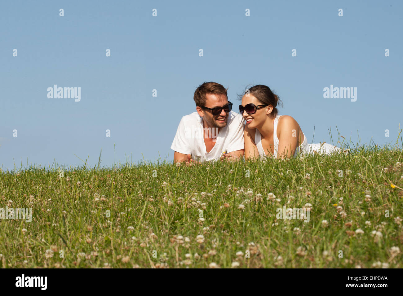 Jeune couple couché dans l'herbe Banque D'Images