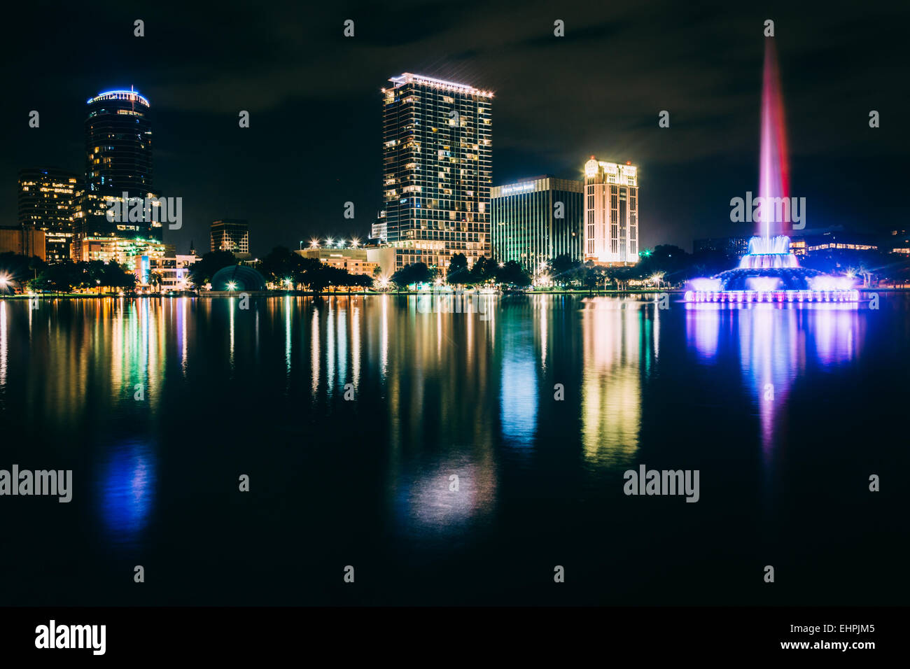 Fontaine et l'Orlando skyline at night, reflétant dans le lac Eola de nuit, à Orlando, Floride. Banque D'Images