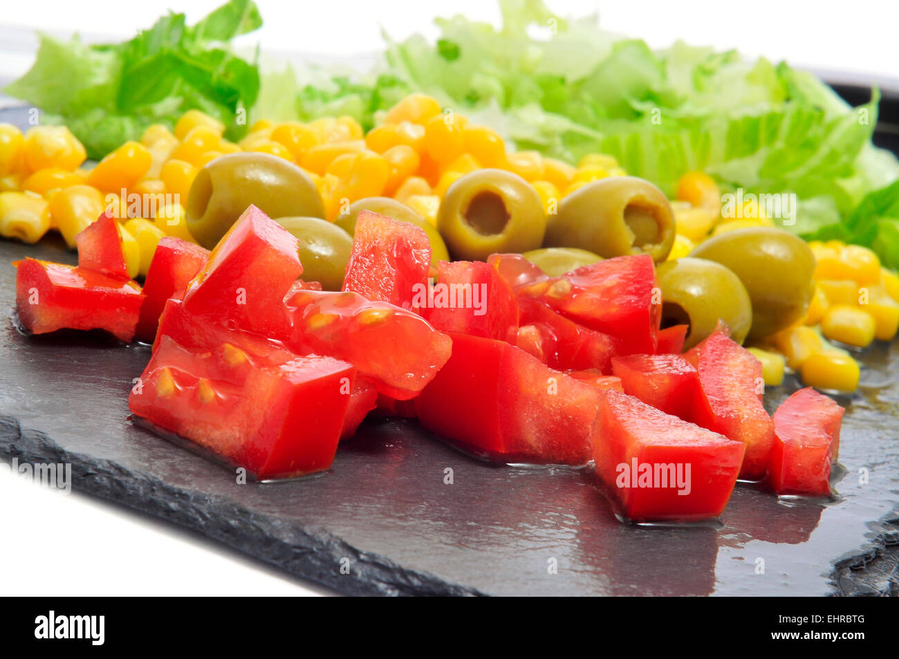Libre de certains ingrédients, comme la tomate, olives, et laitue, sur une surface en ardoise Banque D'Images