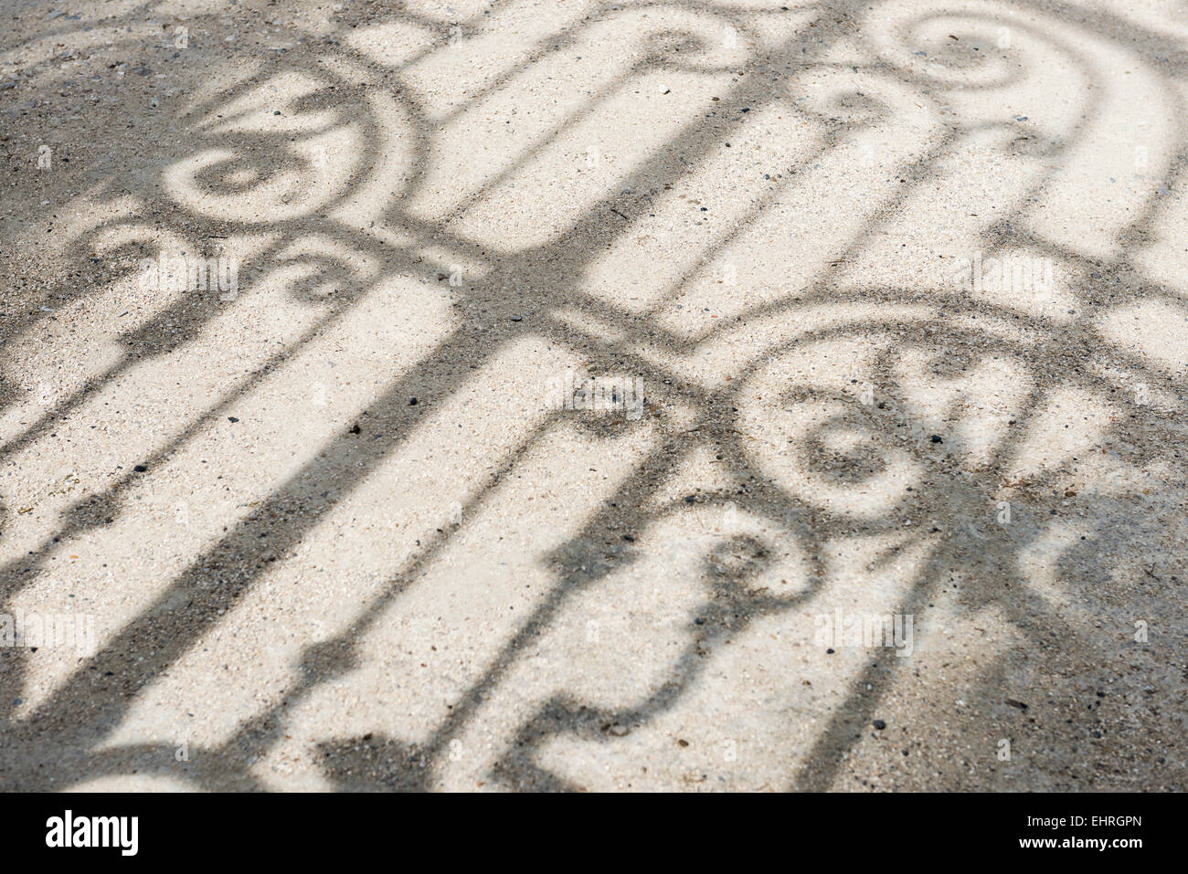 Ombre d'une clôture et la porte sur le sol dans un jardin. Banque D'Images