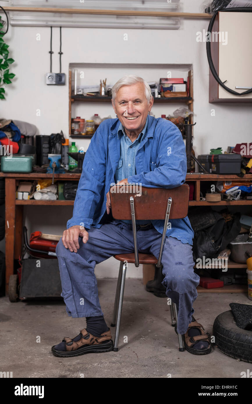 Portrait of happy worker sitting dans son atelier. Banque D'Images