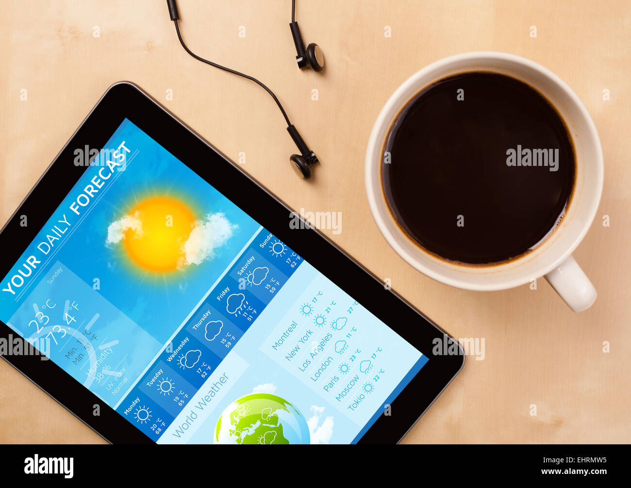 Tablette pc montrant météo à l'écran avec une tasse de café sur un bureau Banque D'Images