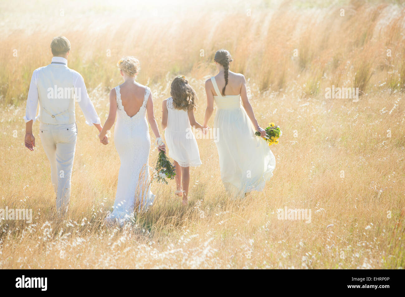 Jeune couple avec et de demoiselle girl walking in meadow Banque D'Images