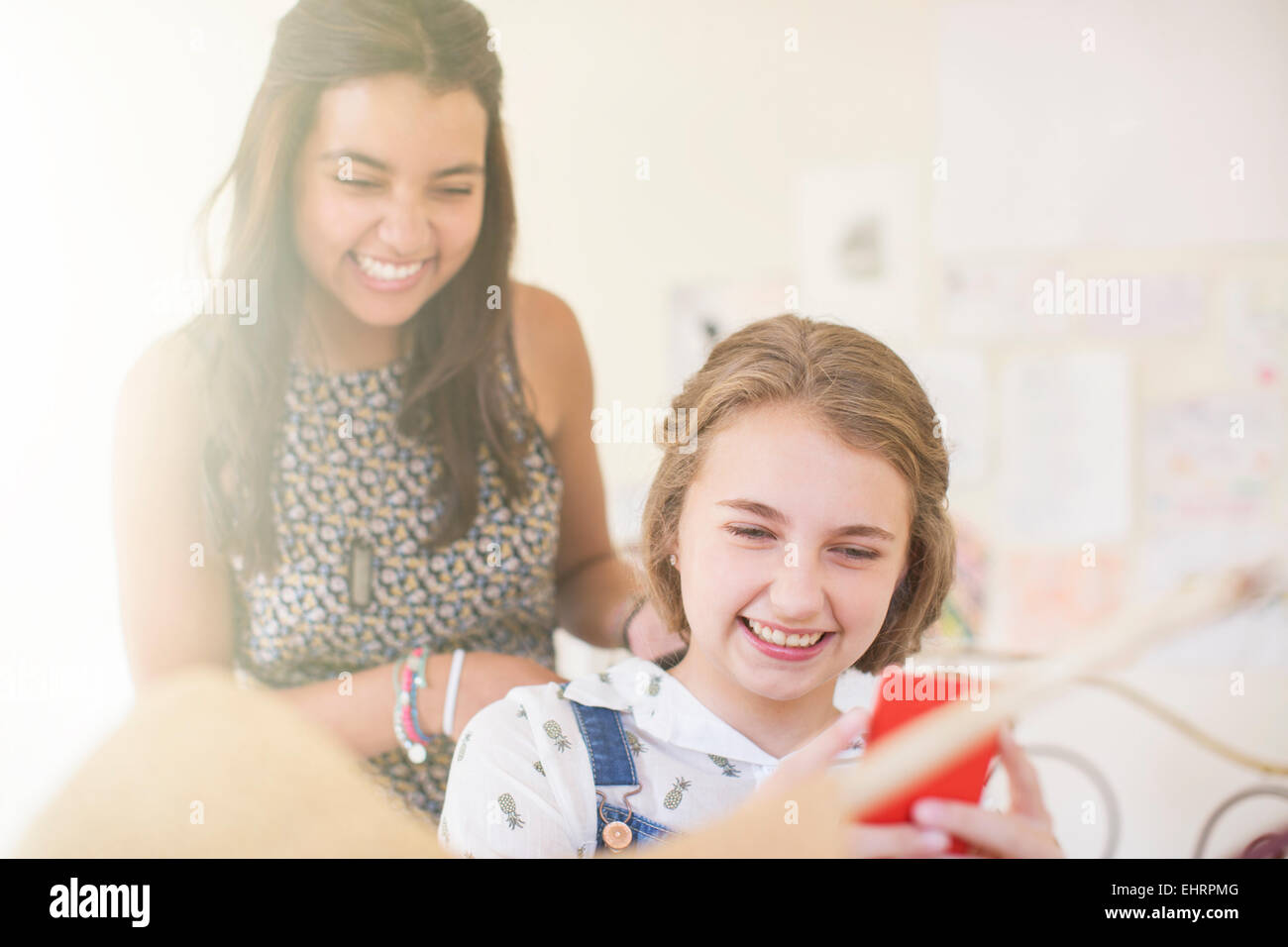 Deux adolescentes smartphone partage and smiling Banque D'Images