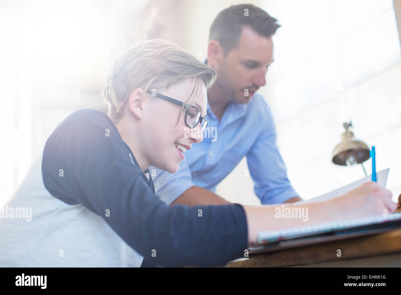 Aider père fils adolescent avec ses devoirs Banque D'Images