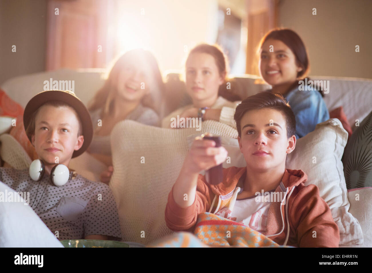 Groupe d'adolescents de regarder la télévision sur un canapé ensemble Banque D'Images