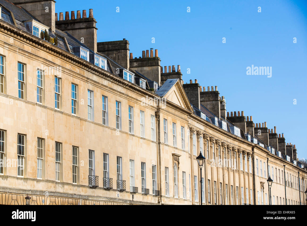 Vue en angle des terrasses de maisons géorgiennes à Bath, Somerset, lors d'une journée ensoleillée avec ciel bleu clair. Banque D'Images