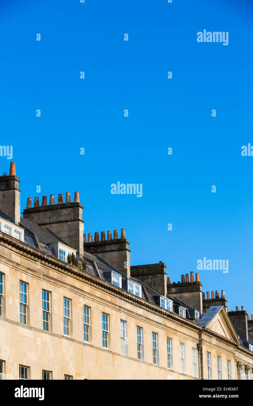 Vue en angle des terrasses de maisons géorgiennes à Bath, Somerset, lors d'une journée ensoleillée avec ciel bleu clair. Banque D'Images