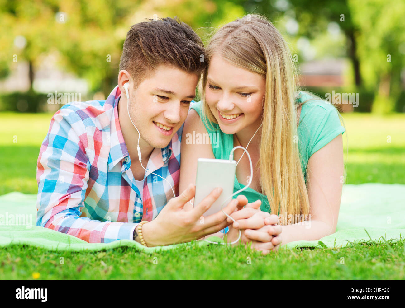 Smiling couple avec le smartphone et écouteurs Banque D'Images