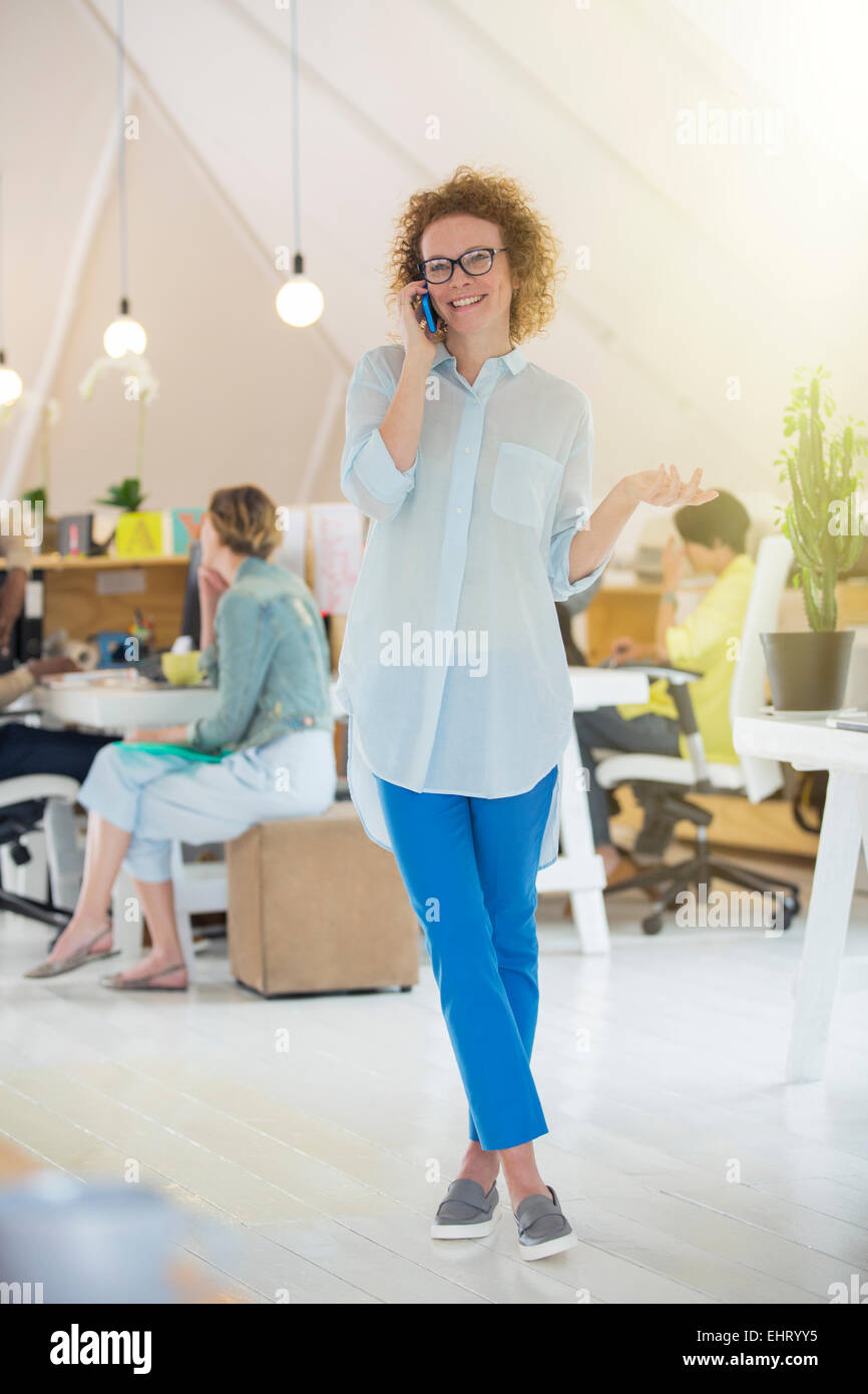 Portrait of Woman talking on phone at office Banque D'Images