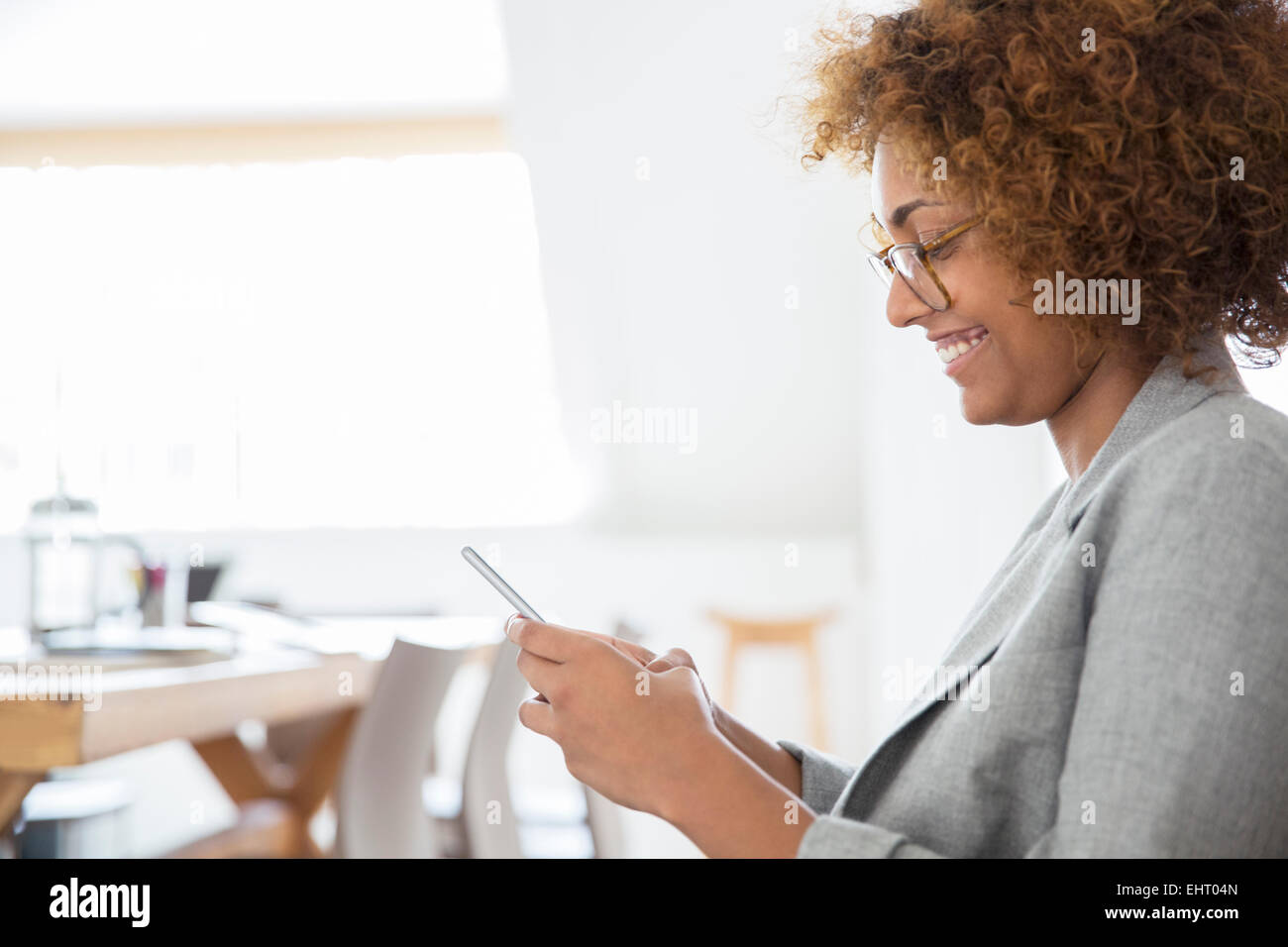 Portrait of woman using smart phone and smiling Banque D'Images