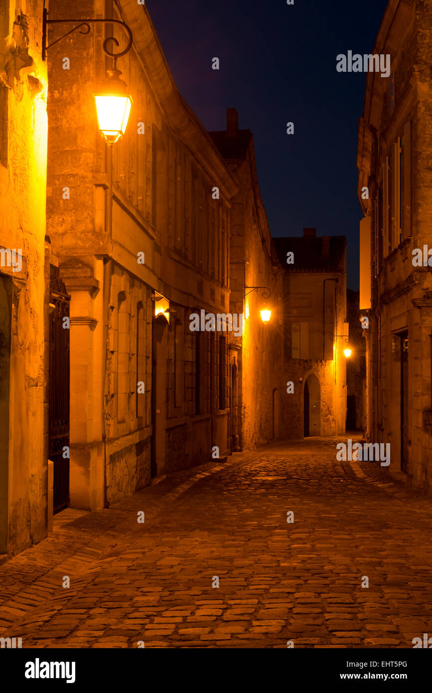 Rue pittoresque de nuit avec des vieilles lanternes dans la cité du vin Saint-Emilion. Banque D'Images