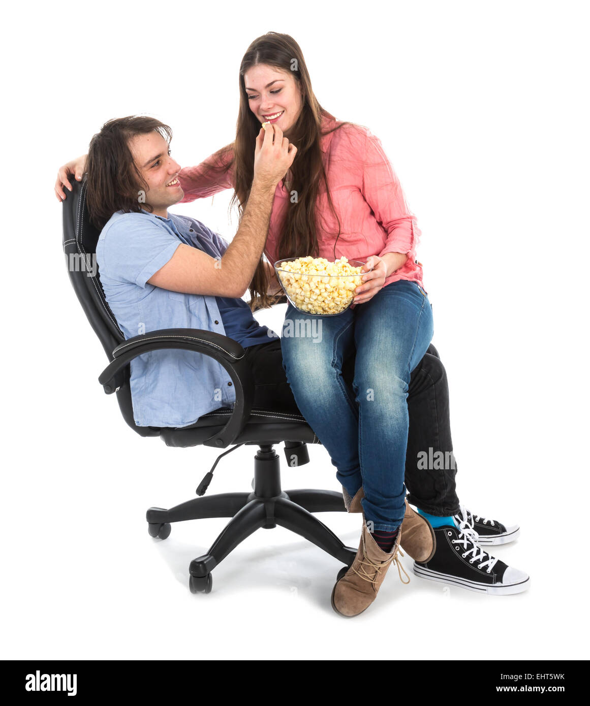 L'homme et la femme assis ensemble dans un fauteuil eating pop corn, isolé sur fond blanc Banque D'Images