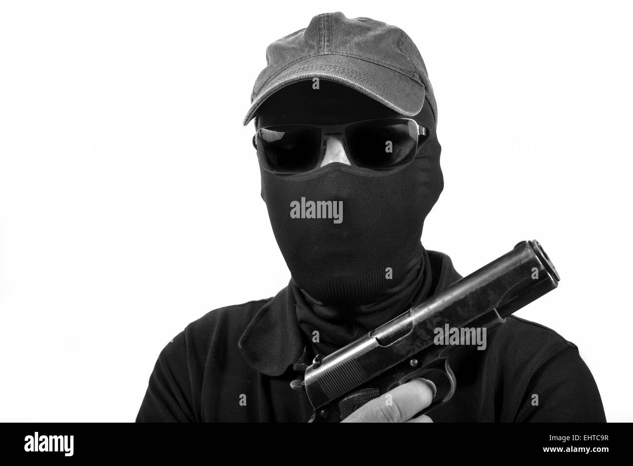 Homme cagoulé avec une arme à feu en noir et blanc Banque D'Images
