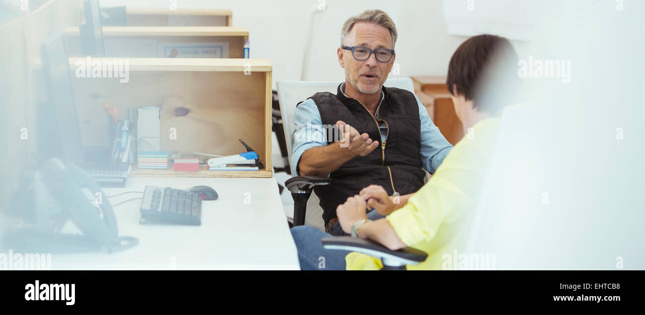 Deux employés de bureau talking at desk Banque D'Images