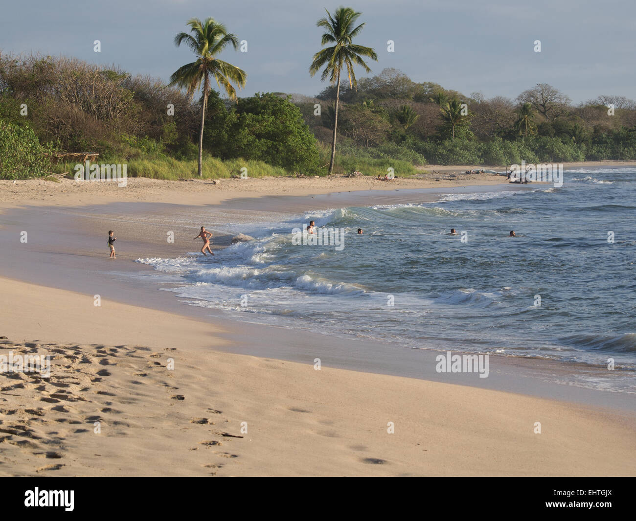 Les personnes jouant dans l'océan à Playa Pelada près de Nosara, Costa Rica. Banque D'Images