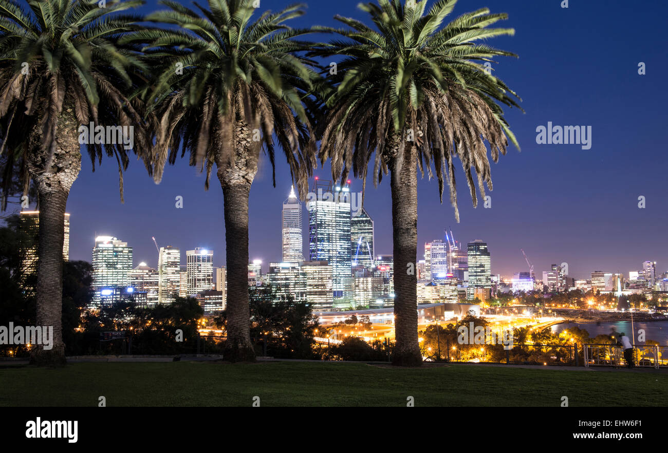 L'horizon de la ville de Perth, au crépuscule, en vue du King's Park avec des palmiers au premier plan. Banque D'Images