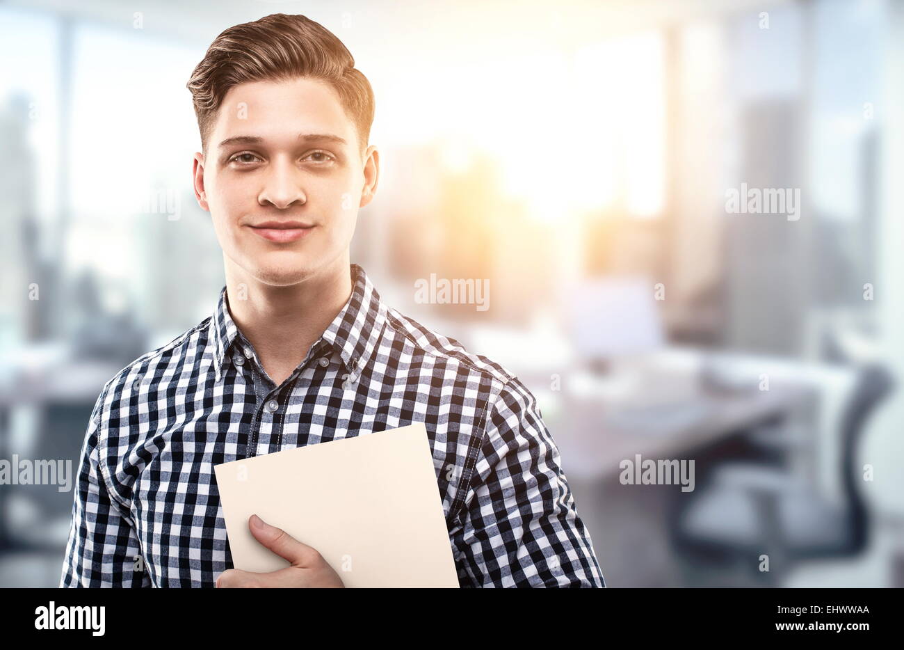 Jeune homme tenant un fichier dans un bureau moderne Banque D'Images