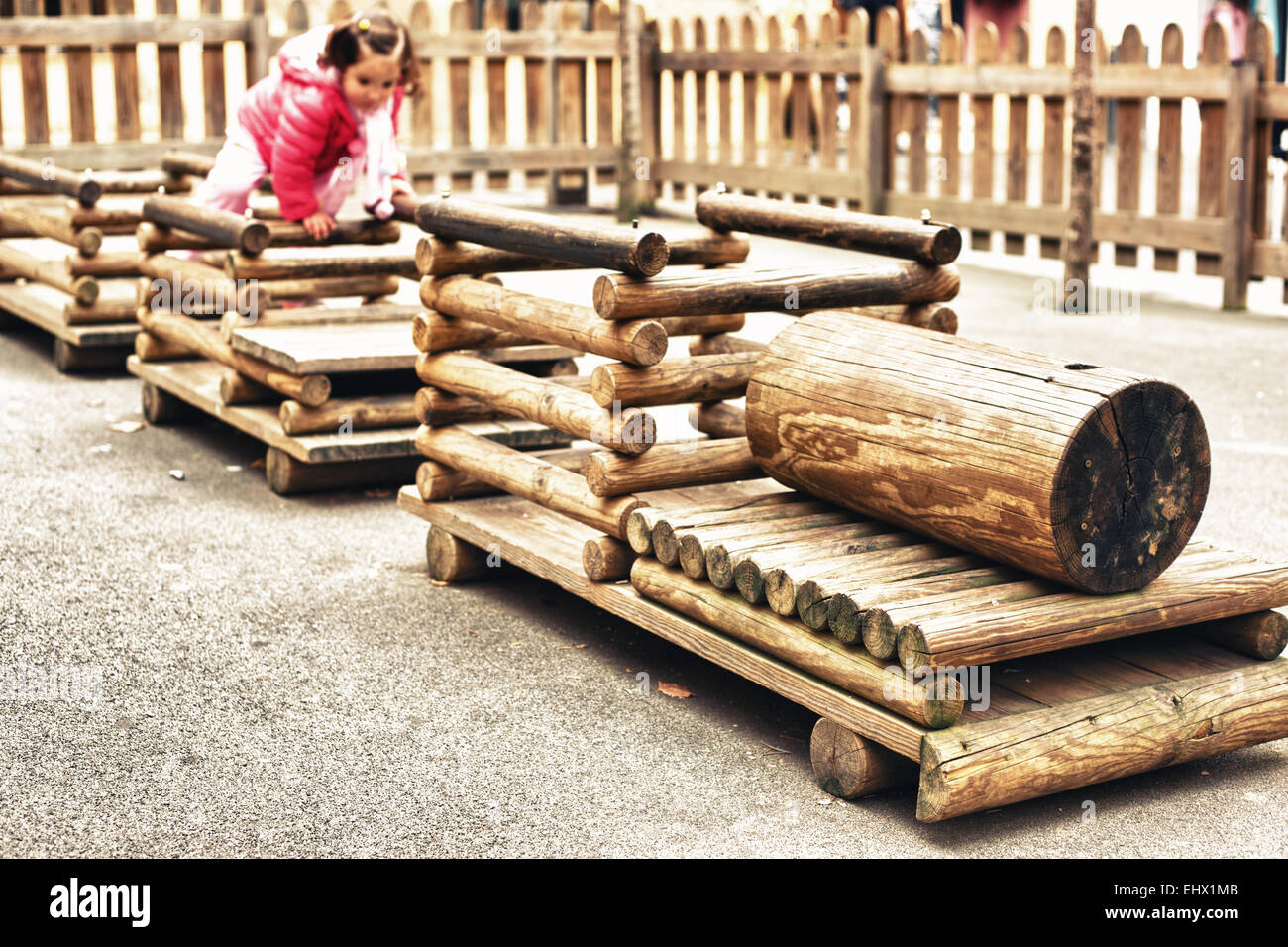 Toddler playing sur un train en bois, une aire de jeux pour enfants dans un parc public Banque D'Images