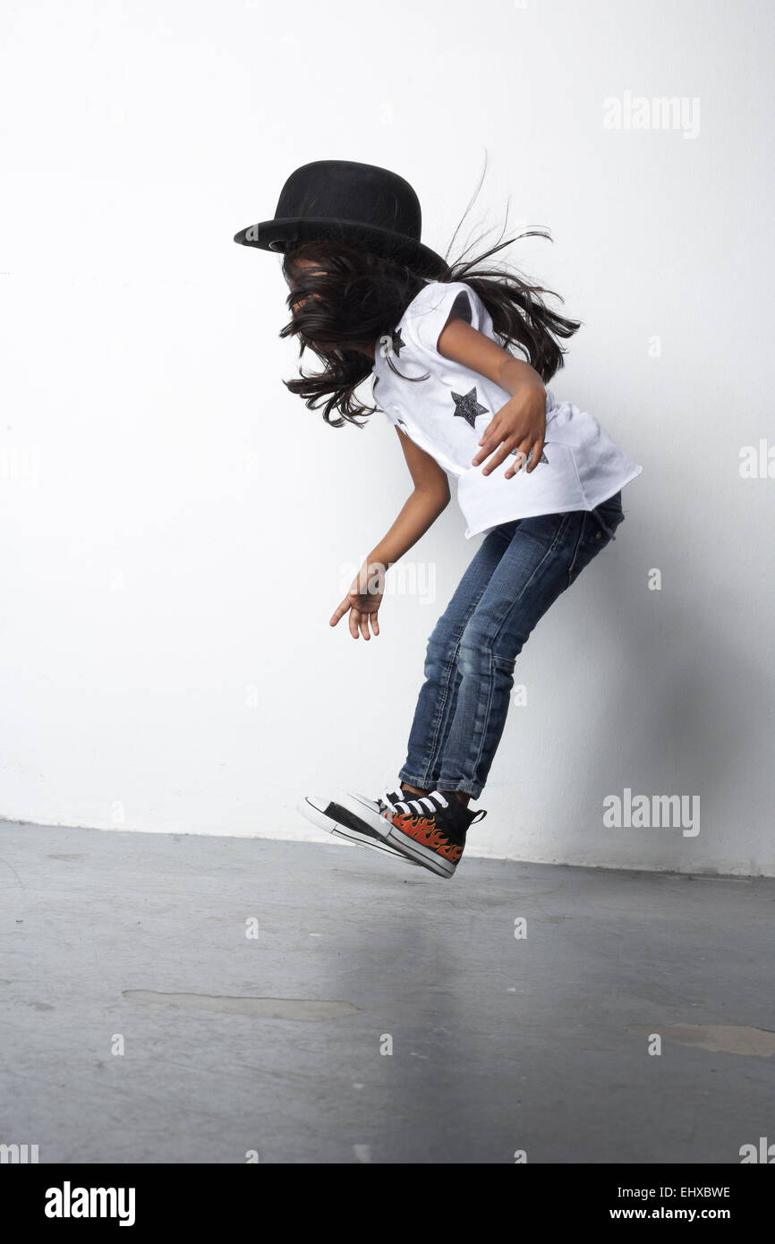 Jumping girl wearing bowler hat Banque D'Images