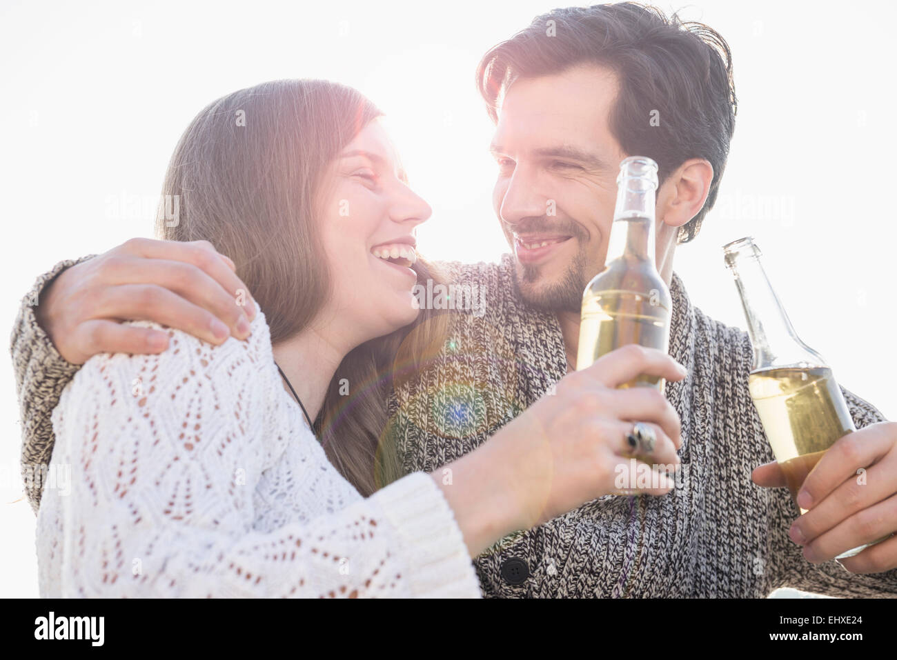 Jeune couple sunset in drinking beer Banque D'Images