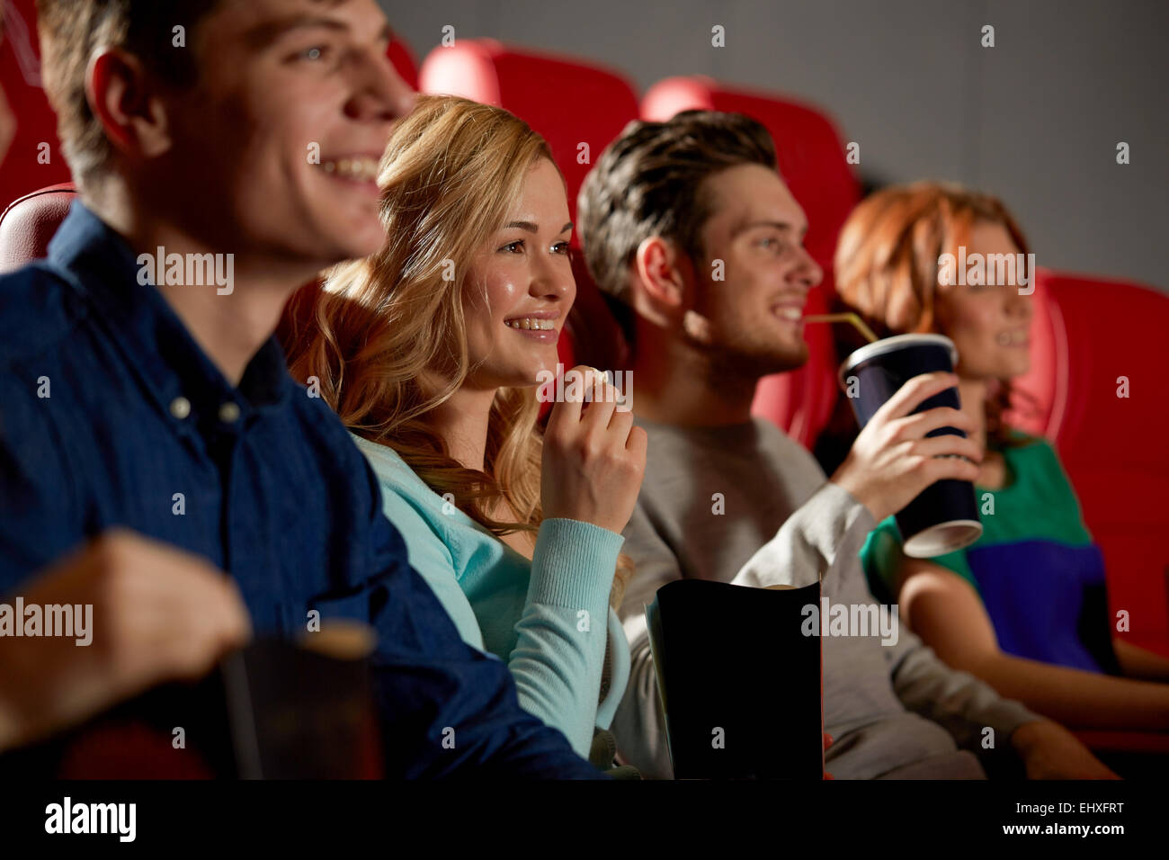 Happy friends watching movie in theatre Banque D'Images