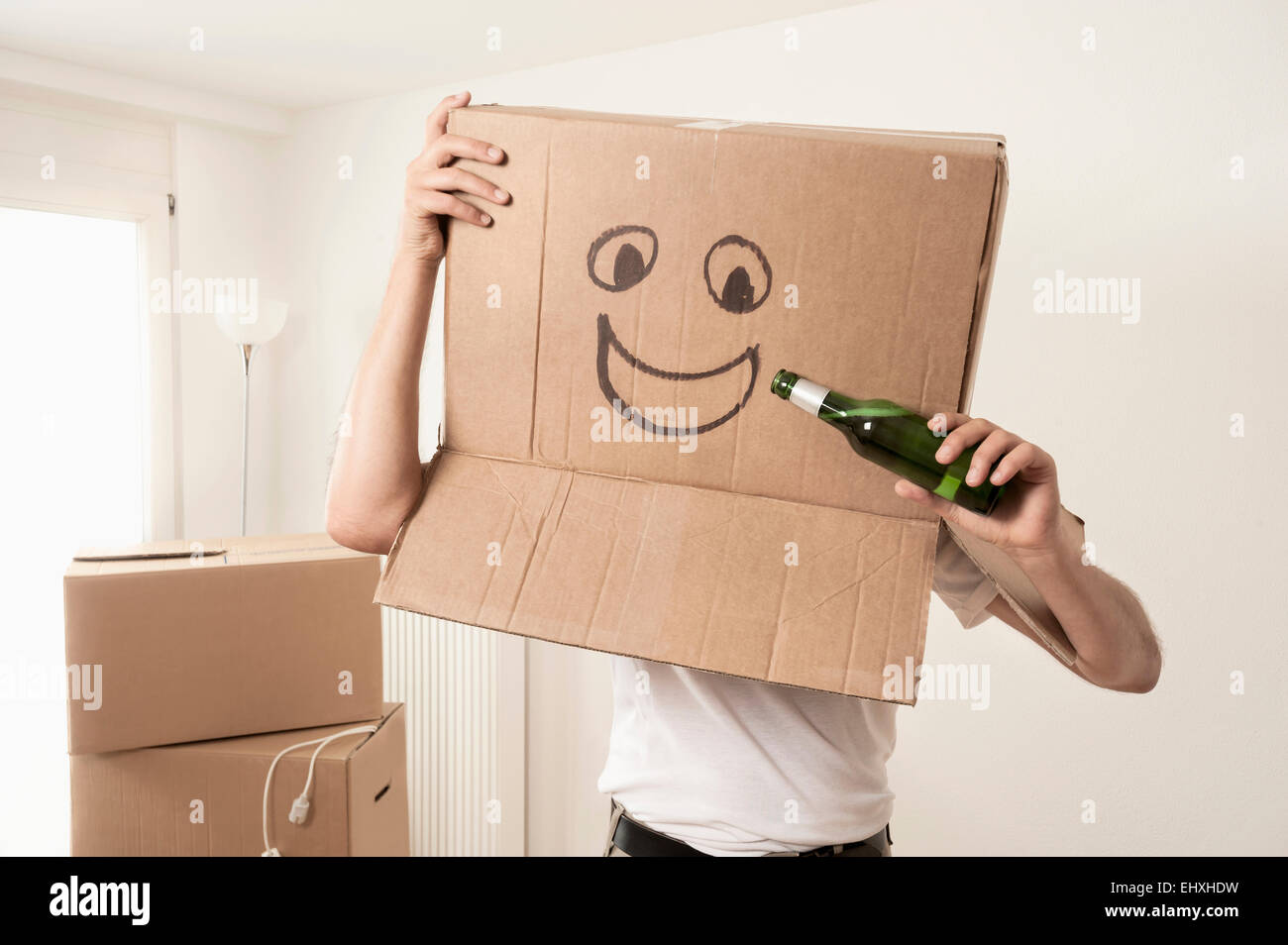 Homme portant un visage heureux déménagement fort sur la tête et faire semblant de boire de la bière, Bavière, Allemagne Banque D'Images