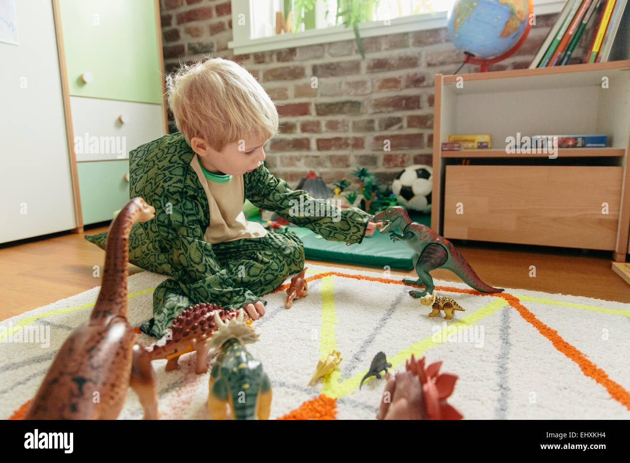 Little Boy wearing costume Playing with toy dinosaure dinosaures Banque D'Images