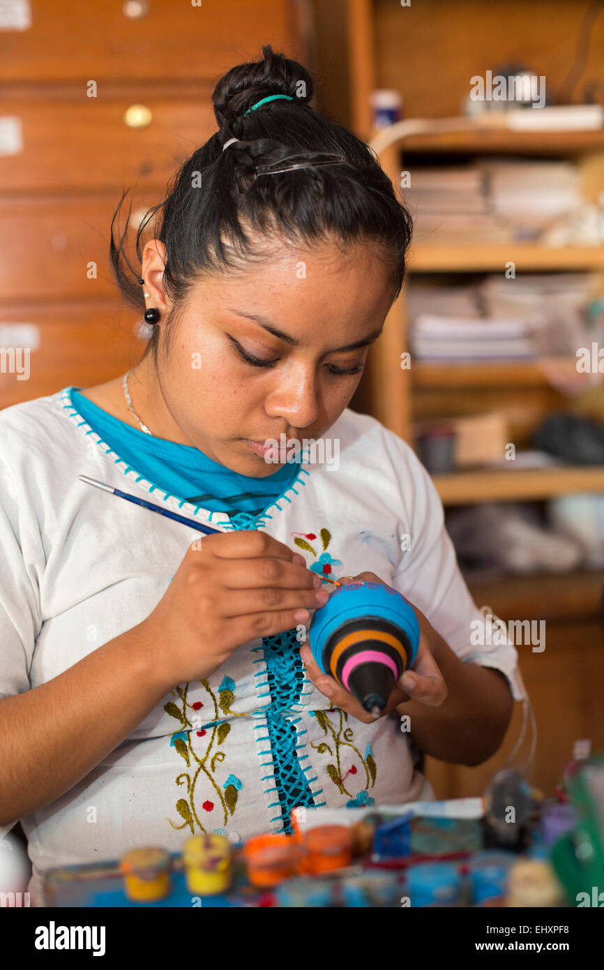 San Martín Tilcajete, Oaxaca, Mexique - Les jeunes femmes dressent des sculptures en bois, connu comme alebrijes. Banque D'Images