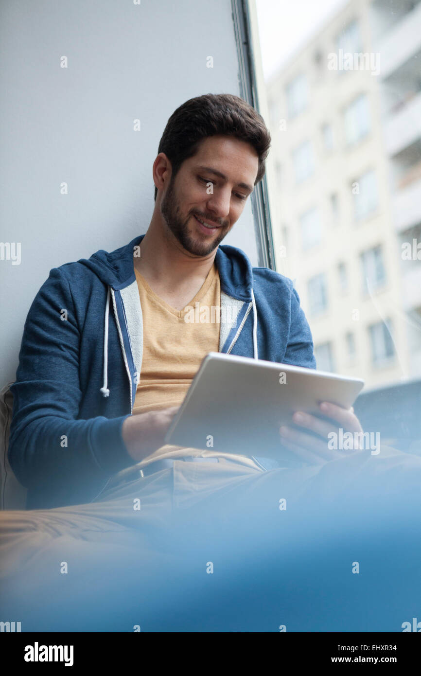 Portrait of smiling man using digital tablet Banque D'Images