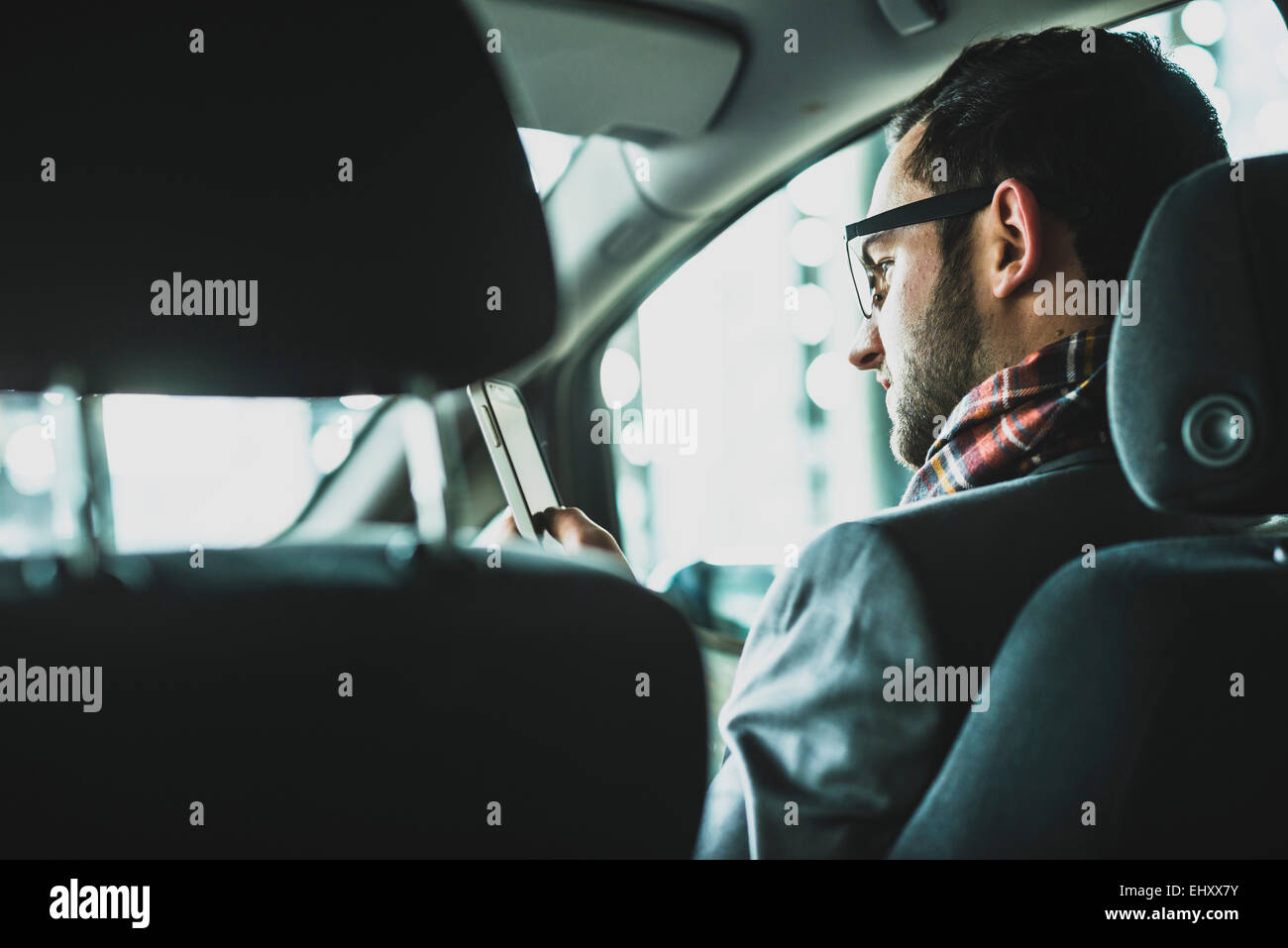 Young businessman in car looking on cell phone Banque D'Images
