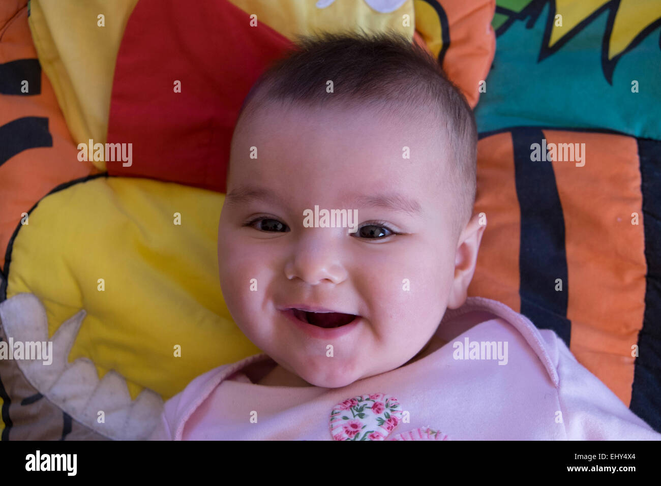 Bébé fille 8 mois, couché sur le plancher, smiling Banque D'Images